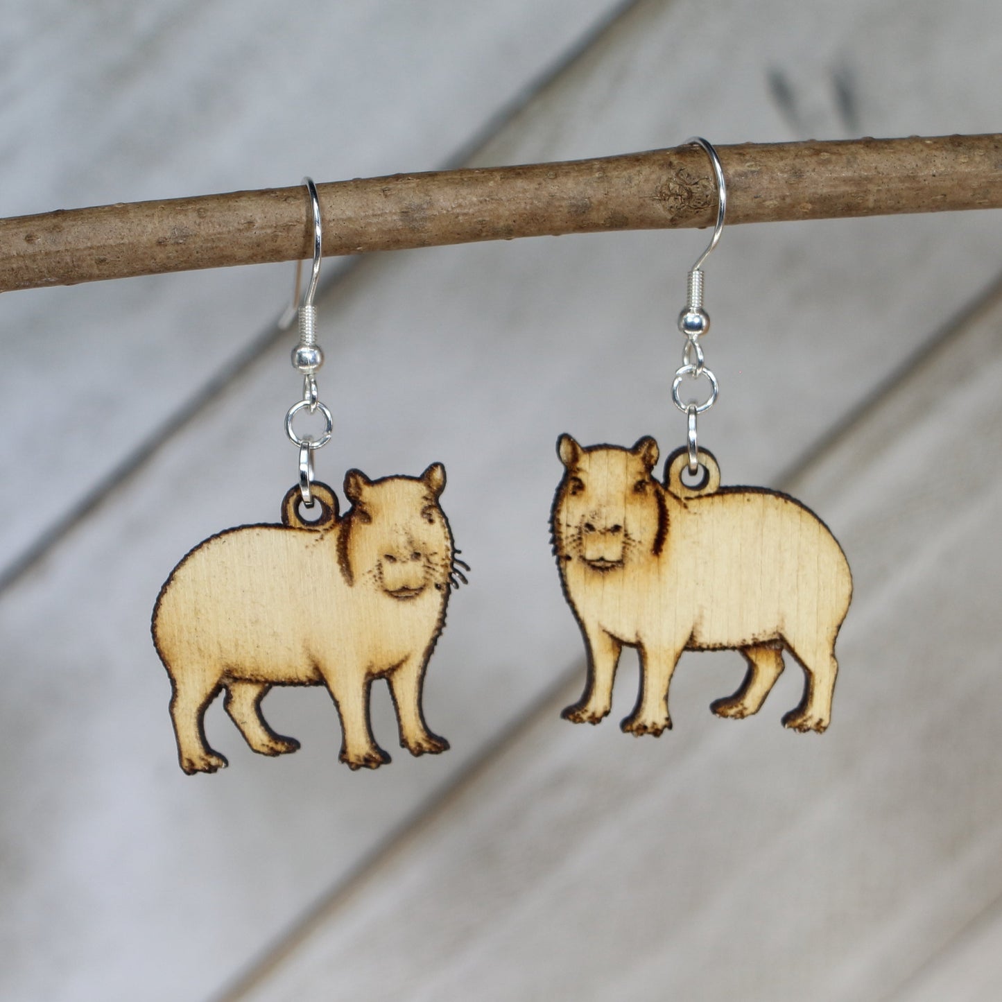 Hand-painted wooden capybara dangle earrings with cute animal design and hypoallergenic sterling silver hooks, lightweight wildlife jewelry for animal lovers and playful style by Cate’s Concepts