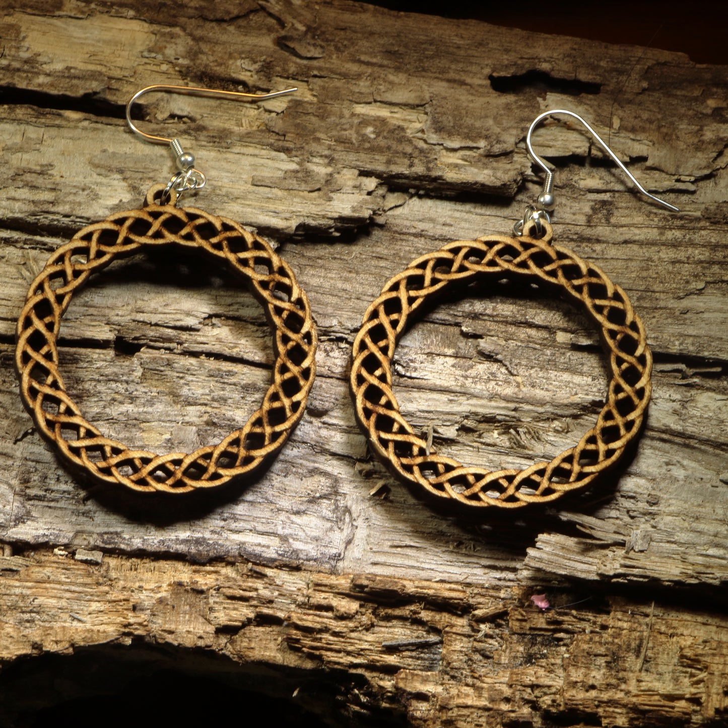 Hand-painted wooden Celtic knot hoop dangle earrings featuring an intricate interwoven Celtic knot design symbolizing eternity, unity, and heritage. Crafted from lightweight wood with hypoallergenic .925 sterling silver hooks, these artisan earrings are perfect for Celtic heritage, Irish and Scottish pride, Renaissance fairs, St. Patrick's Day celebrations, pagan and spiritual jewelry lovers, and anyone who appreciates timeless Celtic-inspired designs.