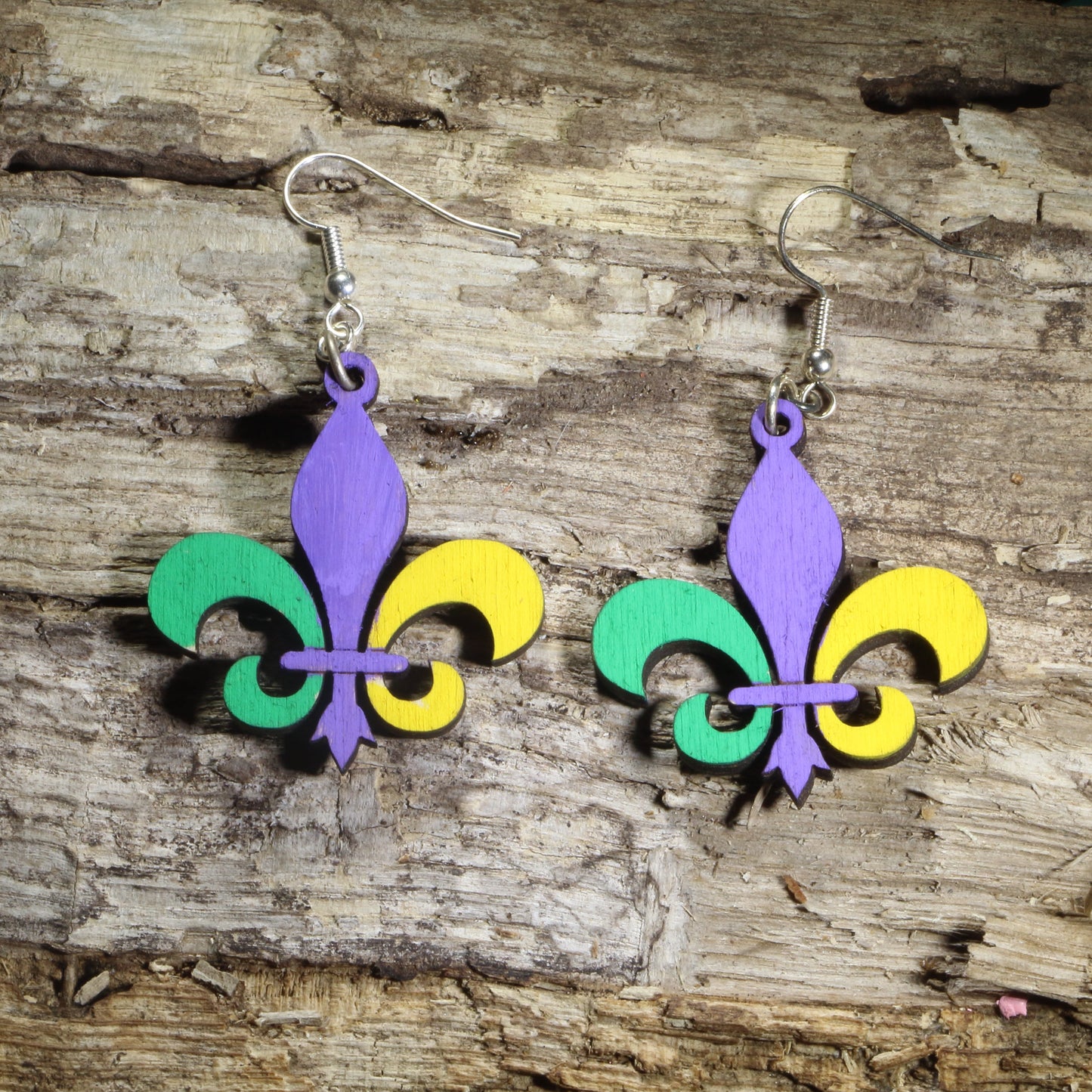 Hand-painted wooden Large Mardi Gras fleur-de-lis dangle earrings featuring the iconic fleur-de-lis in traditional purple, green, and gold on hypoallergenic .925 sterling silver hooks. Lightweight New Orleans jewelry for Mardi Gras celebrations, Louisiana culture, Carnival festivities, festival outfits, and fleur-de-lis enthusiasts.