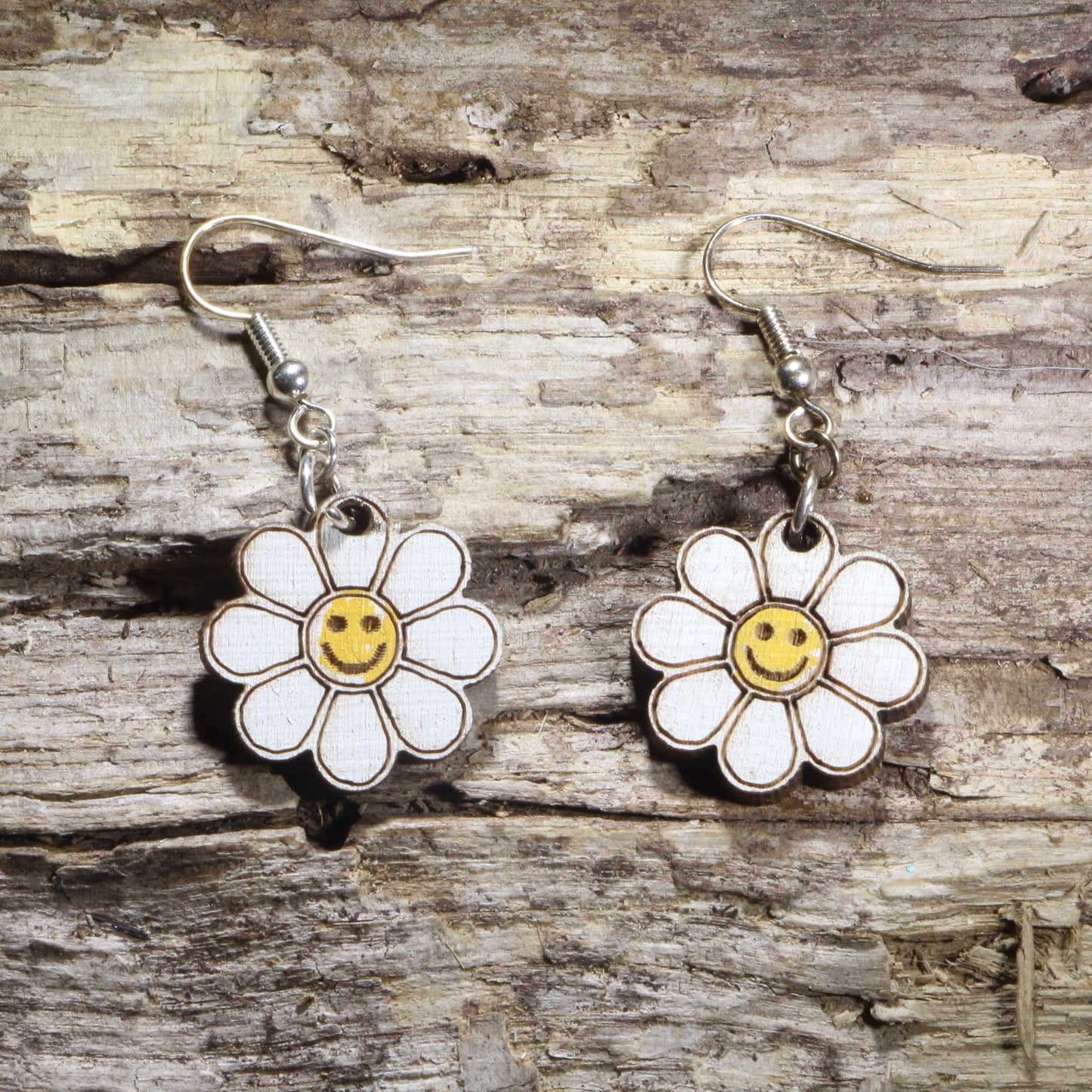 Handcrafted Smiley Daisy wooden dangle earrings featuring cheerful smiling daisy flowers with bright, playful details. Lightweight laser-cut wooden earrings with hypoallergenic .925 sterling silver hooks, perfect for flower lovers, retro 70s fashion, happy aesthetic, spring accessories, cottagecore style, and fun everyday jewelry.