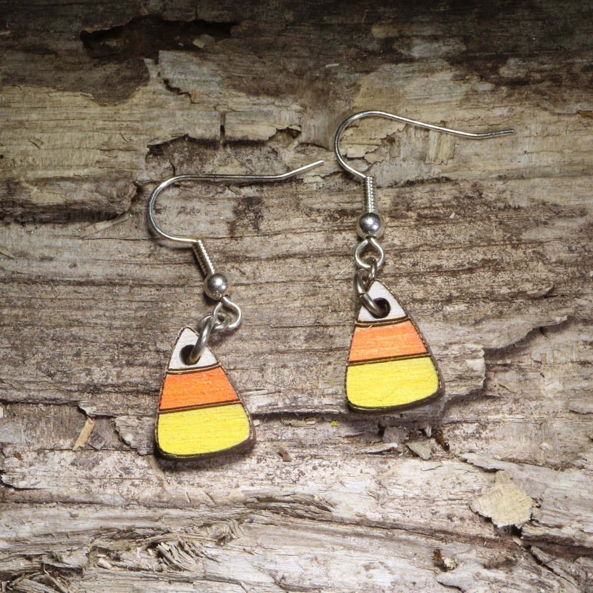 Handcrafted candy corn wooden dangle earrings featuring the classic white, orange, and yellow Halloween candy design. Lightweight hand-painted wooden earrings with hypoallergenic .925 sterling silver hooks, perfect for Halloween parties, trick-or-treat season, spooky fall outfits, candy lovers, and festive autumn accessories.