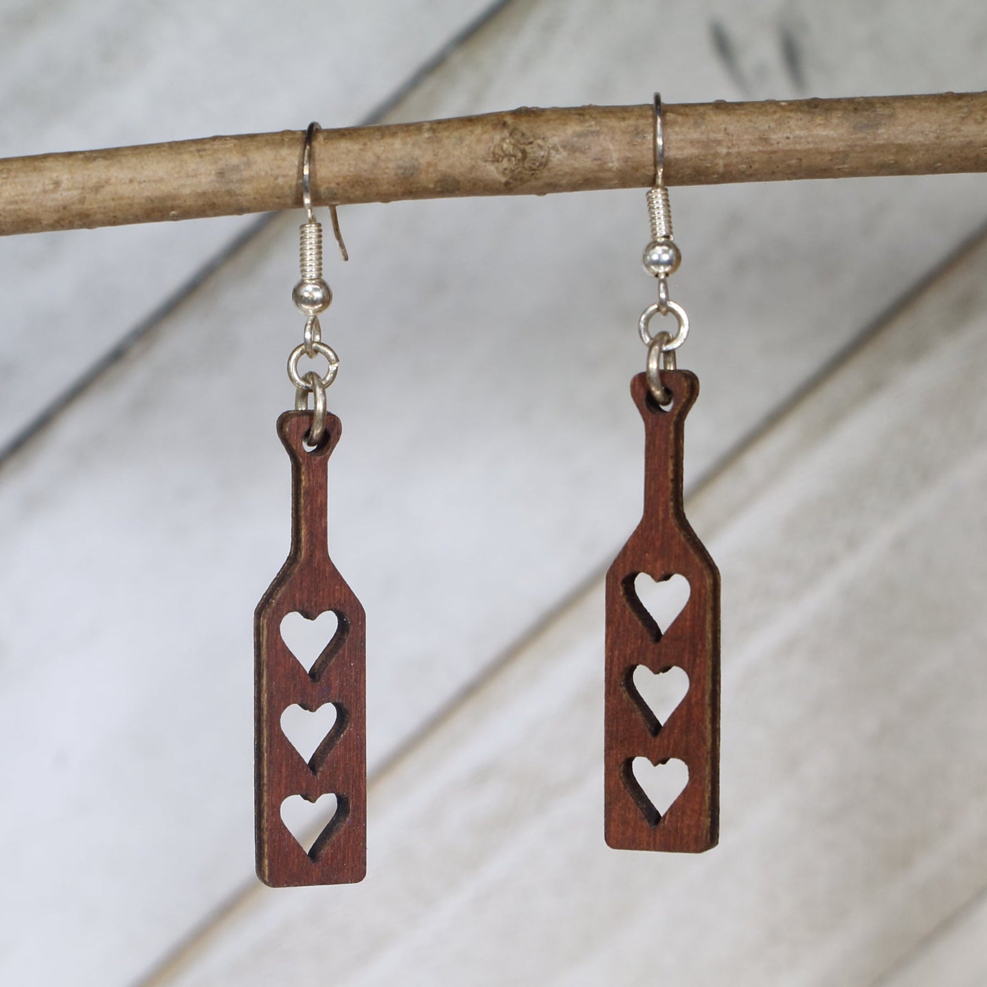 Hand-painted wooden heart paddle dangle earrings featuring a playful heart-shaped paddle design with cheeky humor styling and hypoallergenic sterling silver hooks, lightweight jewelry for fun-loving adults and novelty accessory fans