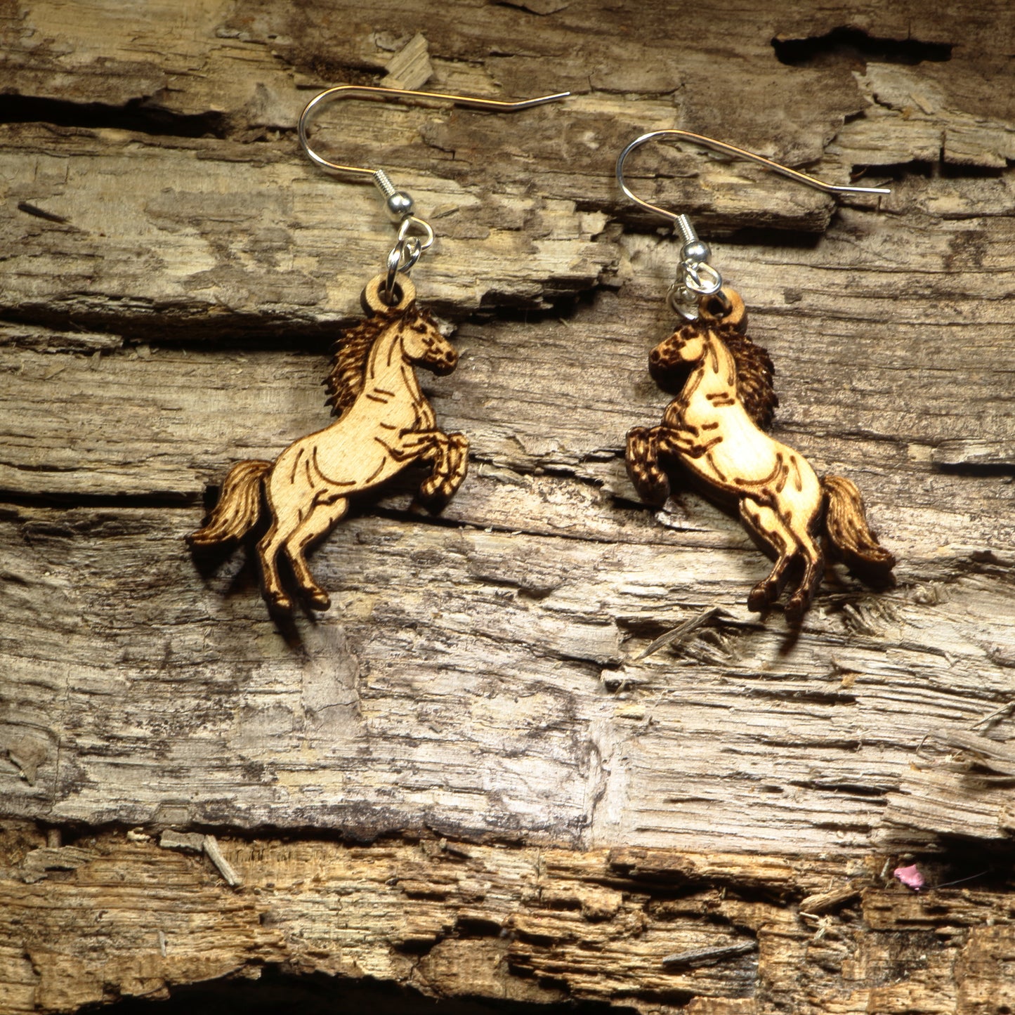Hand-painted wooden rearing horse dangle earrings featuring a majestic horse standing on its hind legs with detailed equestrian artwork. Crafted from lightweight wood with hypoallergenic .925 sterling silver hooks, these artisan earrings are perfect for horse lovers, equestrians, rodeo fans, ranch life, western fashion, country style, and anyone who appreciates the beauty and spirit of horses.