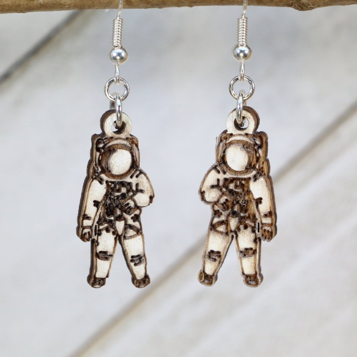 Hand-painted wooden astronaut dangle earrings featuring a detailed space explorer design with helmet visor and suit accents and hypoallergenic sterling silver hooks, lightweight jewelry for space enthusiasts and sci-fi fans by Cate’s Concepts