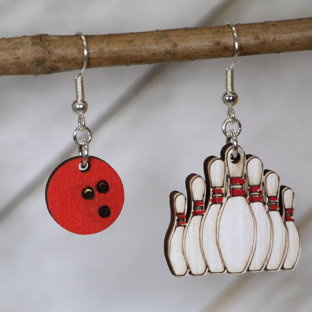 Hand-painted wooden bowling ball and pin dangle earrings featuring a classic black ball with finger holes and standing pin design and hypoallergenic sterling silver hooks, lightweight jewelry for bowlers and league night enthusiasts by Cate’s Concepts