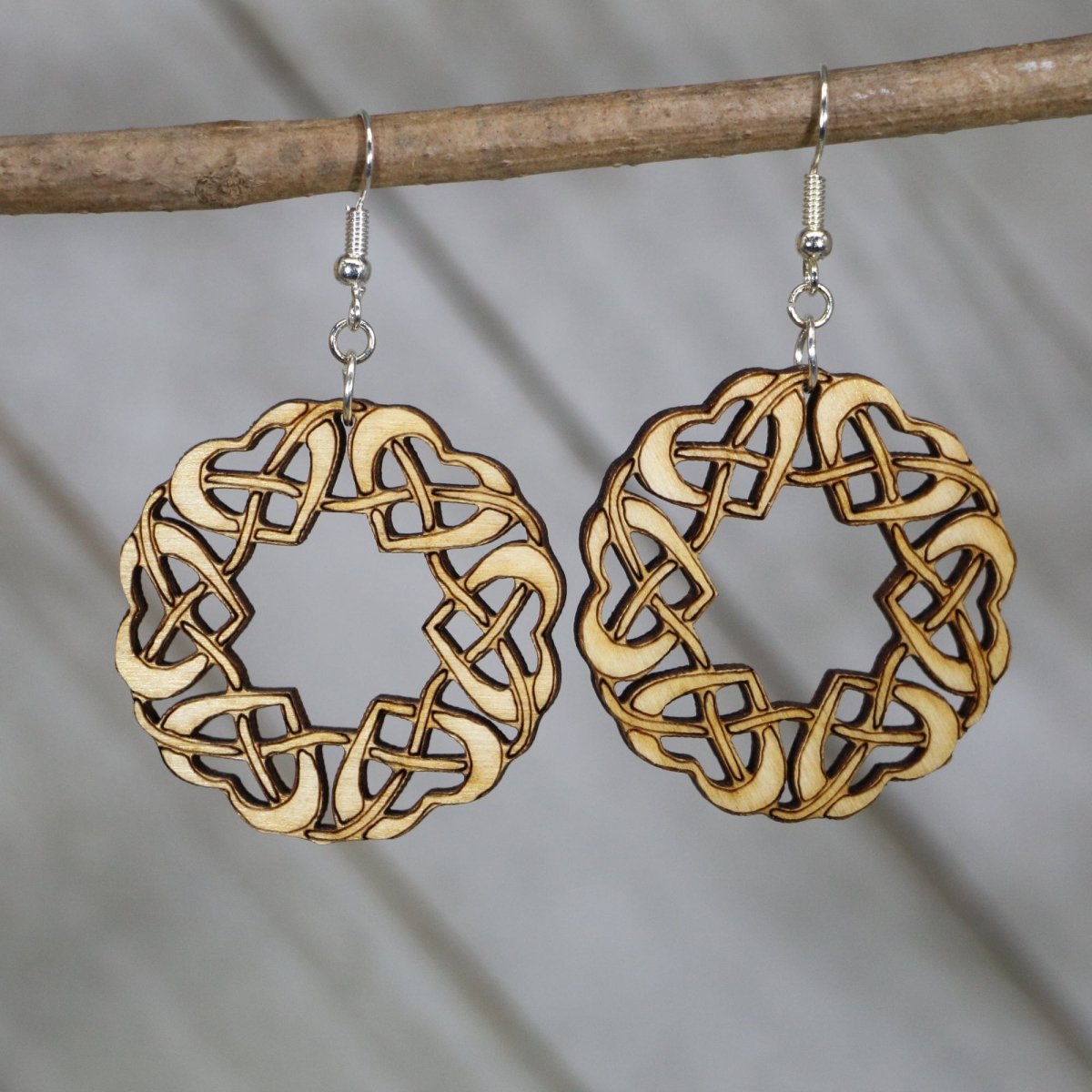Hand-painted wooden Celtic heart dangle earrings featuring an intricate knot circle design with interwoven lines and hypoallergenic sterling silver hooks, lightweight jewelry for Celtic heritage lovers and boho style enthusiasts by Cate’s Concepts