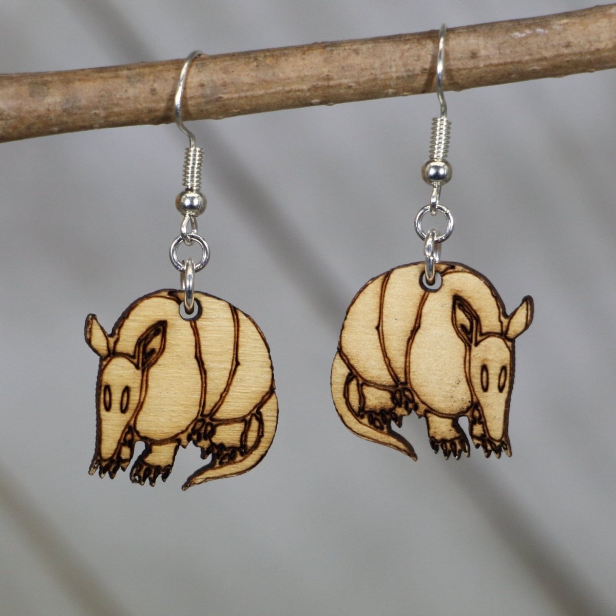 Hand-painted wooden Texas armadillo dangle earrings with realistic desert animal design and hypoallergenic sterling silver hooks, lightweight armadillo statement jewelry earrings for wildlife lovers and Texas style