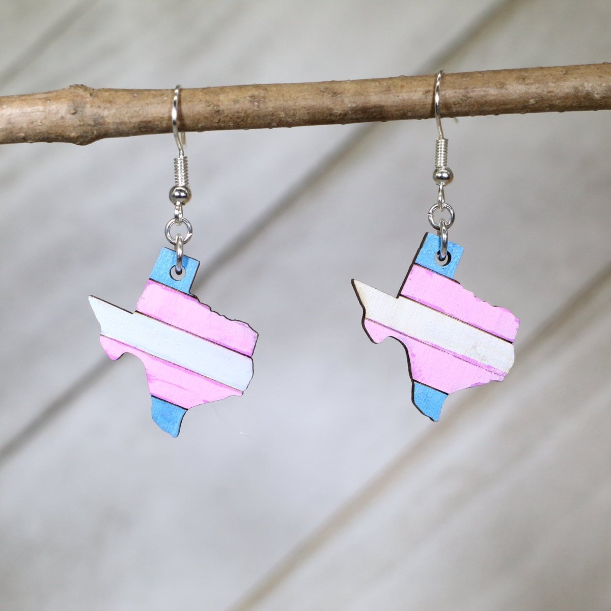 Hand-painted wooden Texas trans pride dangle earrings with transgender flag inspired state design and hypoallergenic sterling silver hooks, lightweight LGBTQ statement jewelry earrings for Texas pride and inclusive style