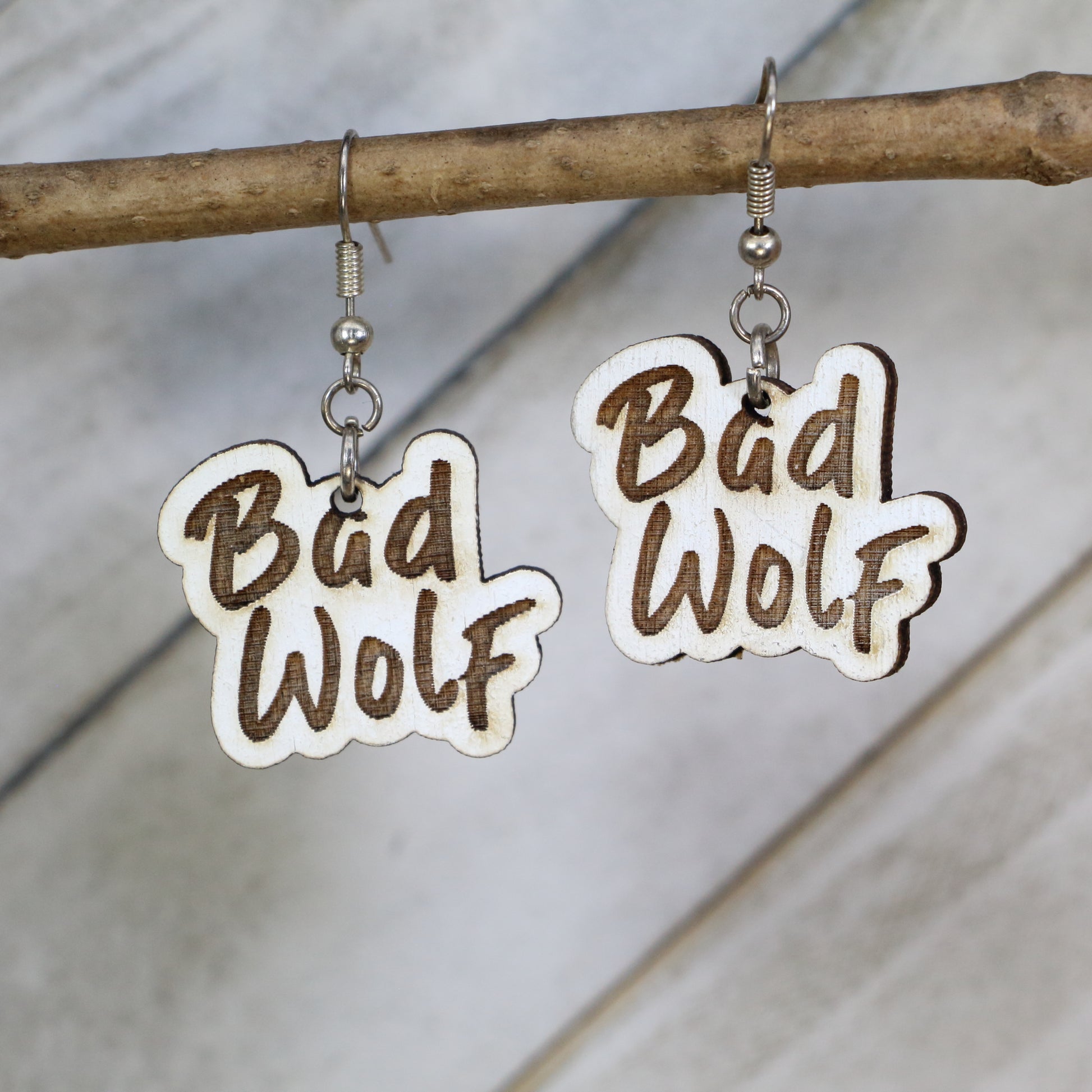 Hand-painted wooden Bad Wolf dangle earrings with sci-fi phrase design and hypoallergenic sterling silver hooks, lightweight fandom statement jewelry earrings for time travel and space lovers 
