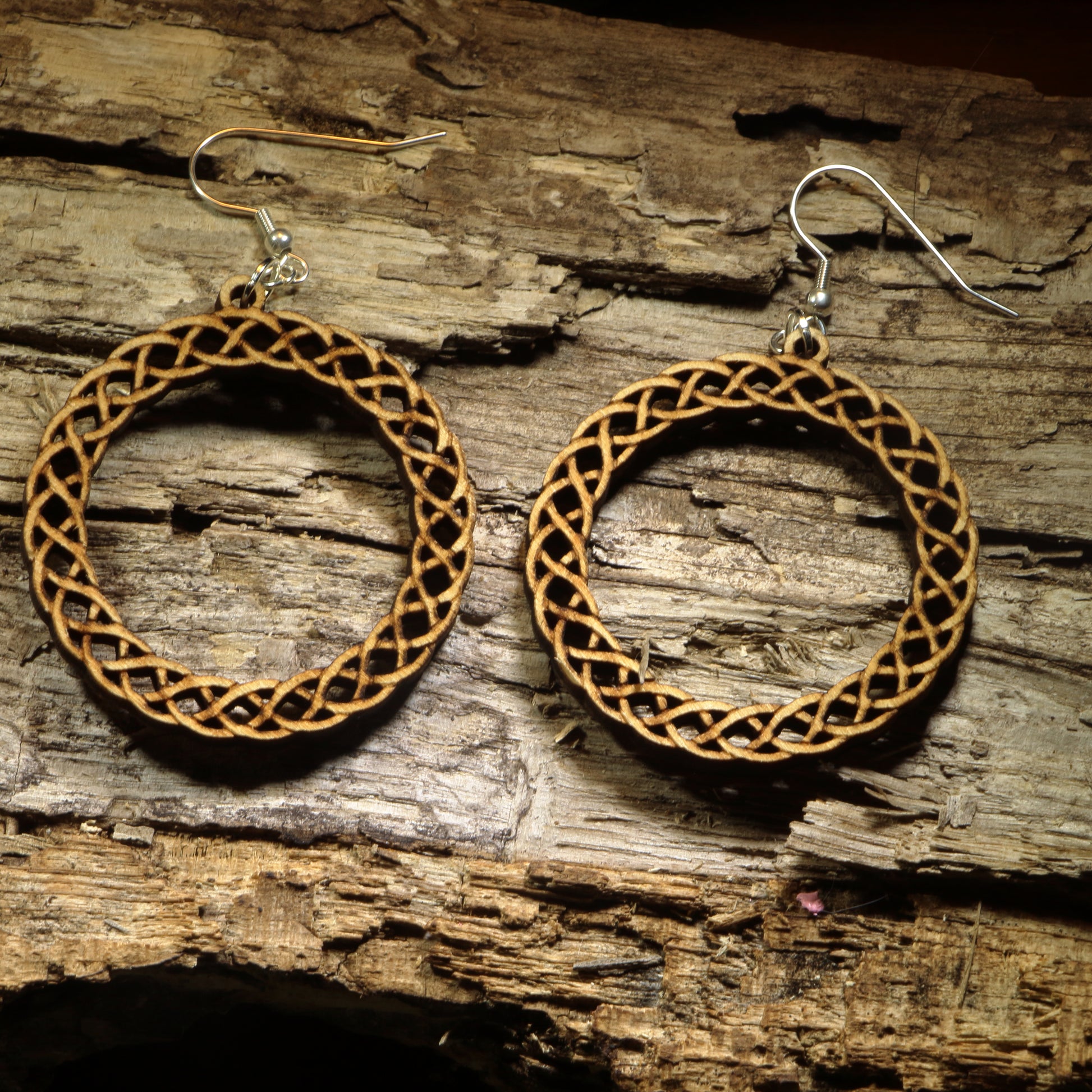 Hand-painted wooden Celtic knot hoop dangle earrings featuring an intricate interwoven Celtic knot design symbolizing eternity, unity, and heritage. Crafted from lightweight wood with hypoallergenic .925 sterling silver hooks, these artisan earrings are perfect for Celtic heritage, Irish and Scottish pride, Renaissance fairs, St. Patrick's Day celebrations, pagan and spiritual jewelry lovers, and anyone who appreciates timeless Celtic-inspired designs.
