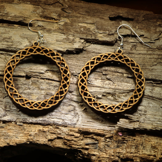 Hand-painted wooden Celtic knot hoop dangle earrings featuring an intricate interwoven Celtic knot design symbolizing eternity, unity, and heritage. Crafted from lightweight wood with hypoallergenic .925 sterling silver hooks, these artisan earrings are perfect for Celtic heritage, Irish and Scottish pride, Renaissance fairs, St. Patrick's Day celebrations, pagan and spiritual jewelry lovers, and anyone who appreciates timeless Celtic-inspired designs.
