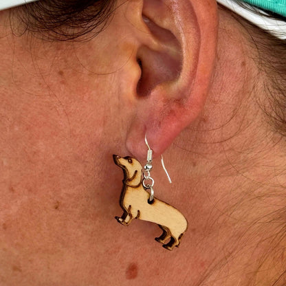 Close-up of handmade wooden Dachshund dangle earring worn on hypoallergenic .925 sterling silver hooks. Lightweight dog lover jewelry featuring a detailed wiener dog silhouette, showing size, fit, and everyday wear for Dachshund enthusiasts.