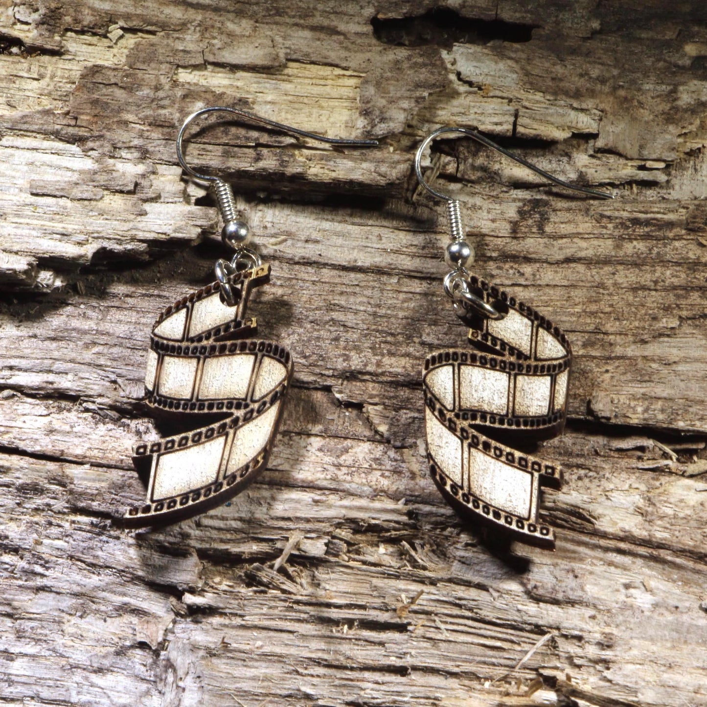 Hand-painted wooden film strip dangle earrings featuring a classic movie reel design. Lightweight cinema-inspired earrings with hypoallergenic .925 sterling silver hooks, perfect for filmmakers, movie lovers, film students, photographers, theater enthusiasts, and anyone passionate about the art of storytelling.