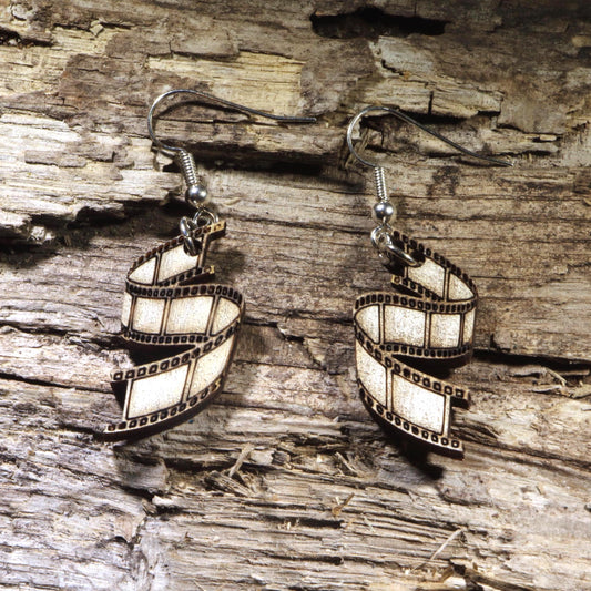 Hand-painted wooden film strip dangle earrings featuring a classic movie reel design. Lightweight cinema-inspired earrings with hypoallergenic .925 sterling silver hooks, perfect for filmmakers, movie lovers, film students, photographers, theater enthusiasts, and anyone passionate about the art of storytelling.