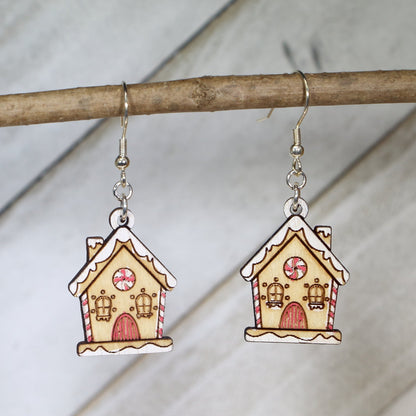 Hand-painted wooden gingerbread house dangle earrings with festive Christmas design and hypoallergenic sterling silver hooks, lightweight holiday jewelry for cookie lovers and cozy winter style by Cate’s Concepts
