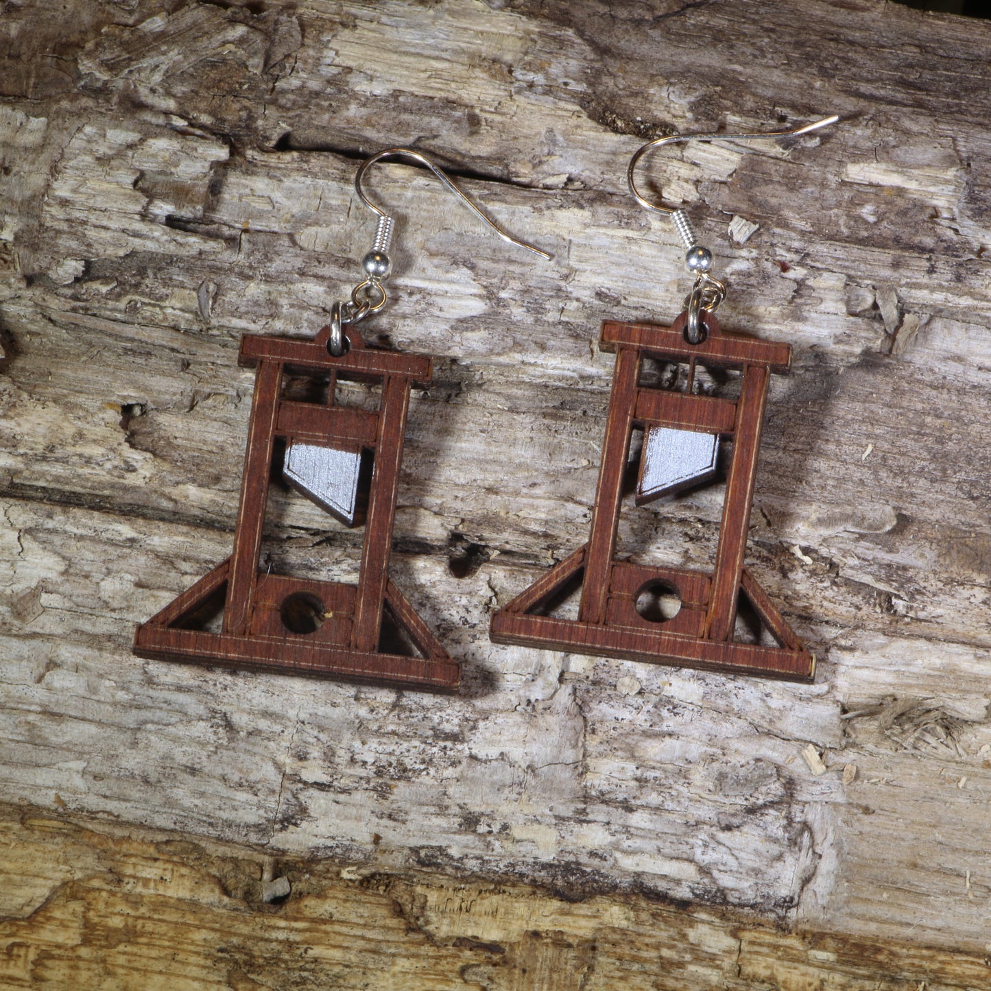 Hand-painted wooden guillotine dangle earrings featuring a detailed French Revolution guillotine design, hypoallergenic sterling silver hooks, and lightweight historical jewelry for history buffs, gothic fashion, and dark humor lovers by Cate’s Concepts.