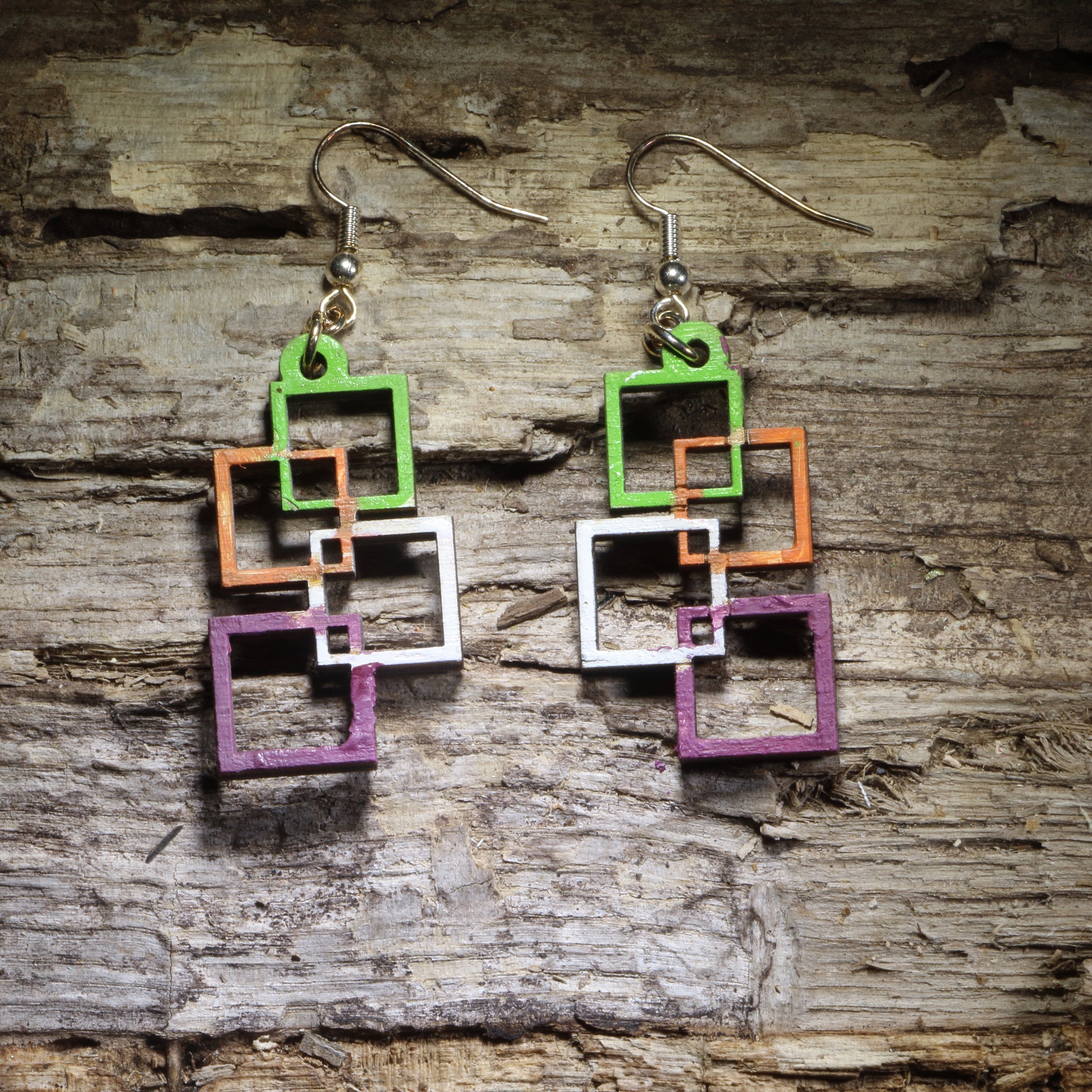 Hand-painted Colorful Interlocking Squares wooden dangle earrings featuring a bold geometric pattern filled with vibrant color. Lightweight and eye-catching, these modern statement earrings are perfect for geometric jewelry lovers, artists, teachers, and anyone who loves colorful accessories.