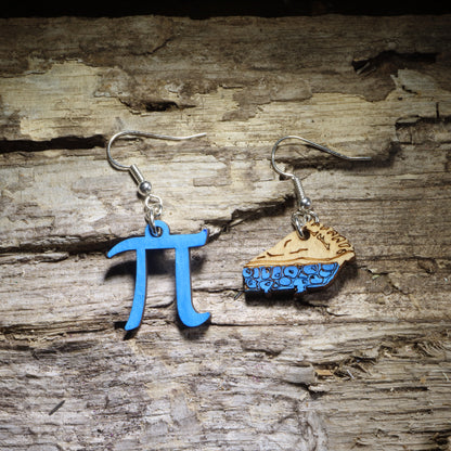 Hand-painted Pi and pie wooden dangle earrings featuring a blue π symbol paired with a slice of blueberry pie. Lightweight math teacher jewelry perfect for Pi Day, math lovers, STEM educators, students, and clever teacher gifts.