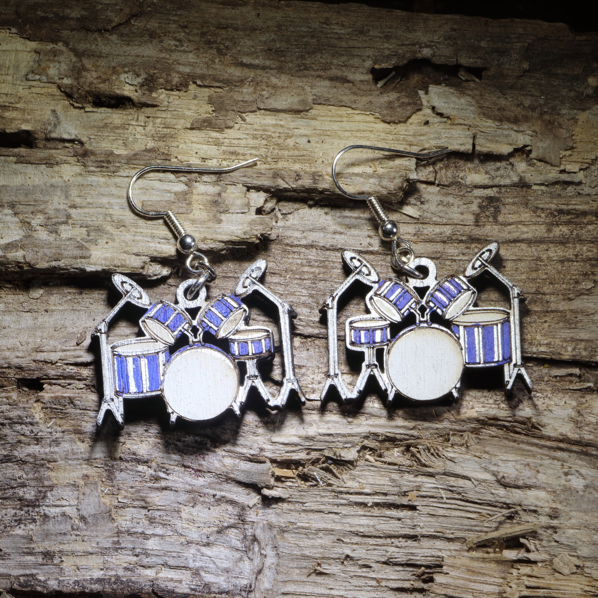 Hand-painted drum set wooden dangle earrings featuring a blue and silver drum kit with cymbals and detailed percussion styling. Lightweight music jewelry perfect for drummers, percussionists, band directors, music teachers, students, and drummer gifts.