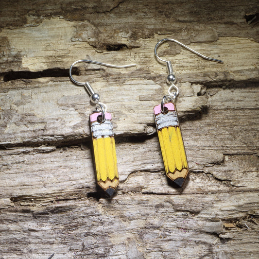 Hand-painted pencil wooden dangle earrings featuring a classic yellow pencil design with pink erasers and sharpened tips. Lightweight teacher earrings perfect for educators, back-to-school outfits, art teachers, writers, and fun classroom jewelry.