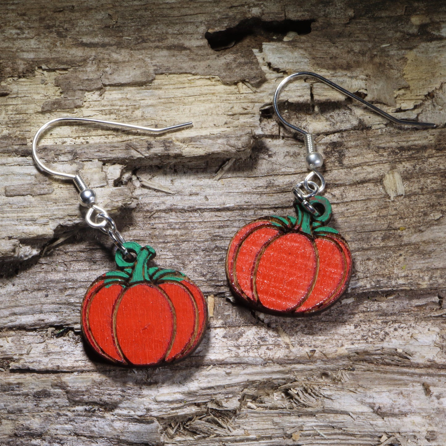 Hand-painted pumpkin wooden dangle earrings featuring a bright orange pumpkin with a green stem. Lightweight fall earrings perfect for pumpkin lovers, Thanksgiving, harvest festivals, autumn outfits, and seasonal fall jewelry.