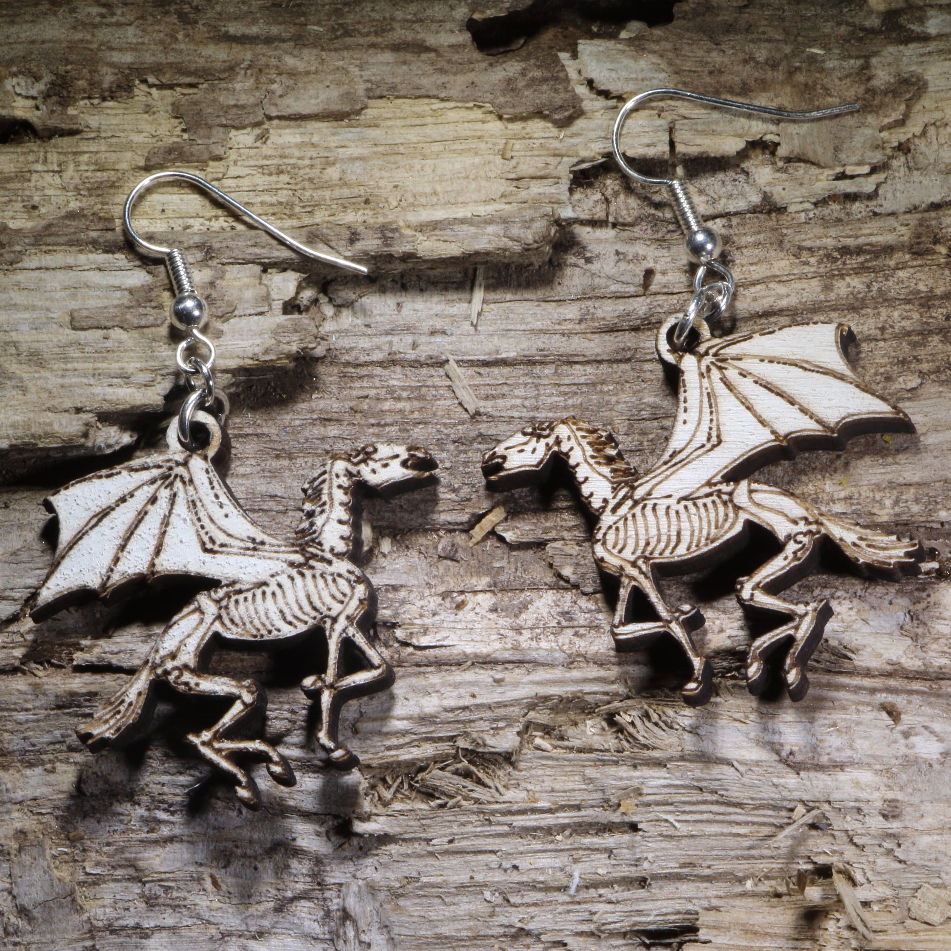 Hand-painted skeletal winged horse wooden dangle earrings featuring a striking fantasy design with gothic flair. Lightweight statement earrings perfect for Pegasus lovers, dark fantasy fans, mythology enthusiasts, and unique gothic jewelry collectors.