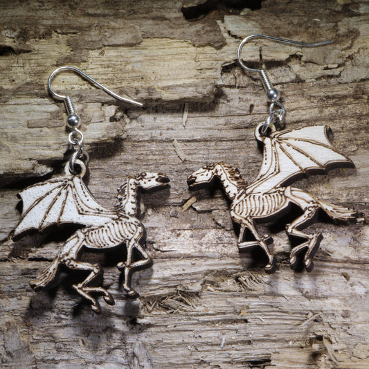 Hand-painted skeletal winged horse wooden dangle earrings featuring a striking fantasy design with gothic flair. Lightweight statement earrings perfect for Pegasus lovers, dark fantasy fans, mythology enthusiasts, and unique gothic jewelry collectors.