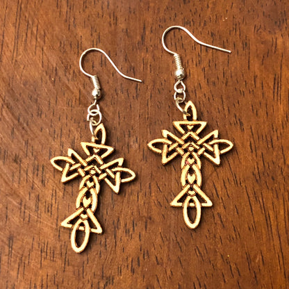 Hand-painted wooden Celtic cross dangle earrings with an intricate Celtic knot pattern on hypoallergenic .925 sterling silver hooks, displayed on a wood tabletop. Lightweight Christian faith jewelry inspired by Irish and Celtic heritage, perfect for church, Easter, everyday wear, and meaningful gifts.