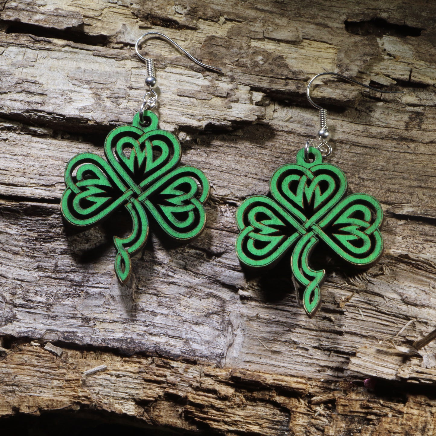 Hand-painted wooden Celtic knot shamrock dangle earrings featuring an intricate four-leaf shamrock inspired by traditional Celtic knotwork. Lightweight wooden earrings with hypoallergenic .925 sterling silver hooks, perfect for St. Patrick's Day celebrations, Irish heritage, Celtic jewelry lovers, and lucky everyday style.