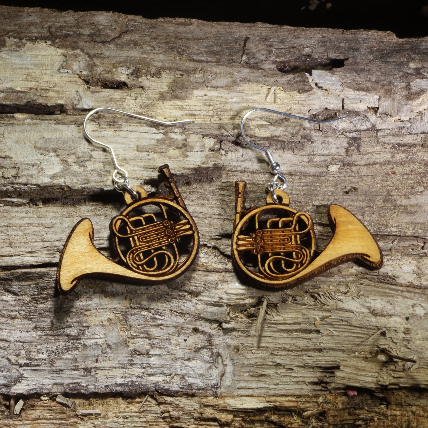 Hand-painted wooden French horn dangle earrings featuring detailed French horns with engraved tubing and bell accents on hypoallergenic .925 sterling silver hooks. Lightweight music jewelry for French horn players, band directors, orchestra musicians, music teachers, brass instrument enthusiasts, and marching band members.