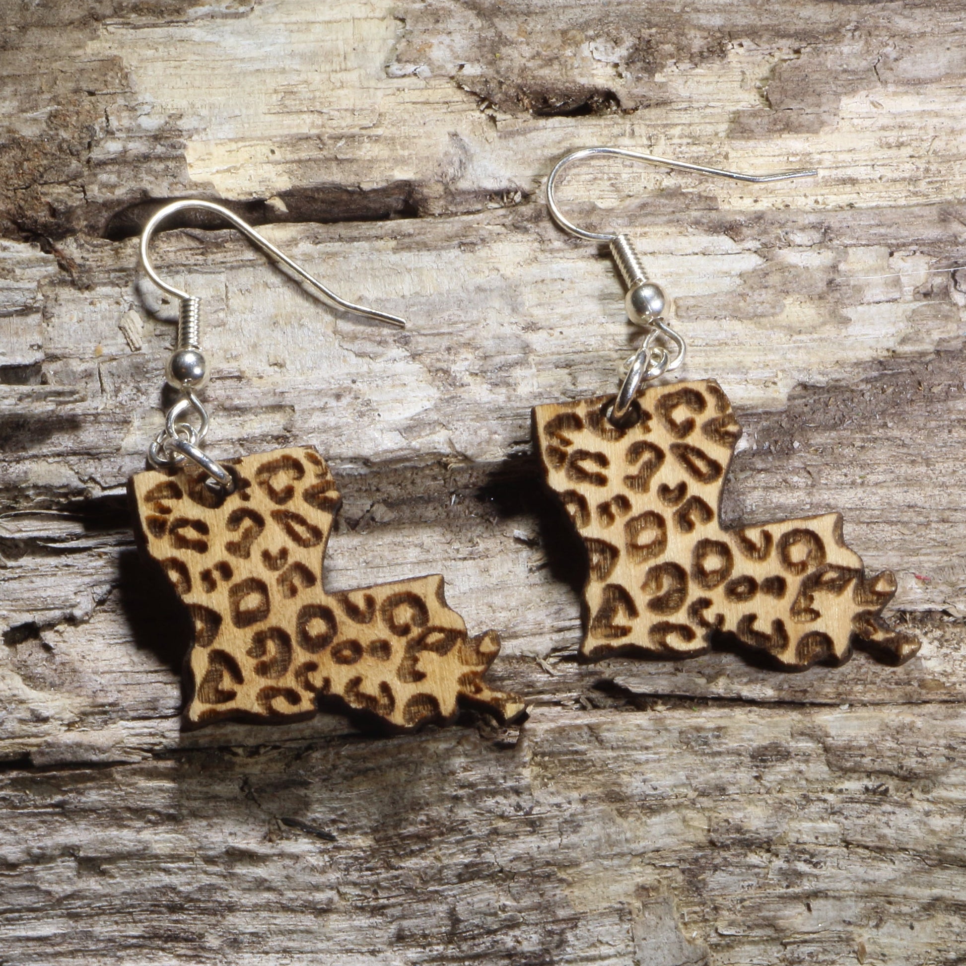 Hand-painted wooden Louisiana dangle earrings featuring a tan leopard print pattern on hypoallergenic .925 sterling silver hooks. Lightweight Louisiana-themed jewelry for animal print lovers, hometown pride, travel souvenirs, and unique regional accessories.