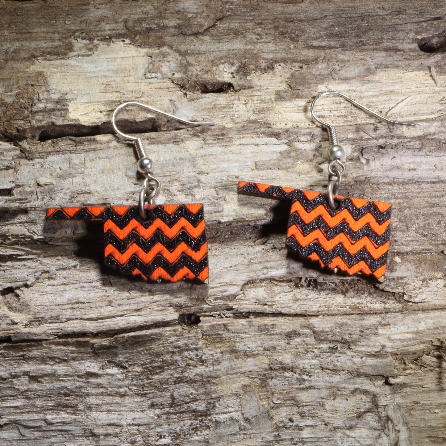 Hand-painted wooden Oklahoma dangle earrings featuring a bold orange and black chevron pattern on hypoallergenic .925 sterling silver hooks. Lightweight Oklahoma-themed jewelry for game day, hometown pride, travel souvenirs, and unique regional accessories.