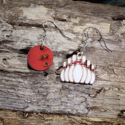 Hand-painted wooden bowling ball and bowling pins mismatched dangle earrings featuring a red bowling ball and a full rack of ten pins on hypoallergenic .925 sterling silver hooks. Lightweight bowling jewelry for league bowlers, tournament players, bowling coaches, alley enthusiasts, and anyone who loves the sport of bowling.