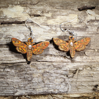 Hand-painted wooden hawk moth dangle earrings featuring detailed orange, gold, and brown wings on hypoallergenic .925 sterling silver hooks. Lightweight moth-inspired jewelry for insect lovers, entomologists, nature enthusiasts, cottagecore fashion, and wildlife gifts.