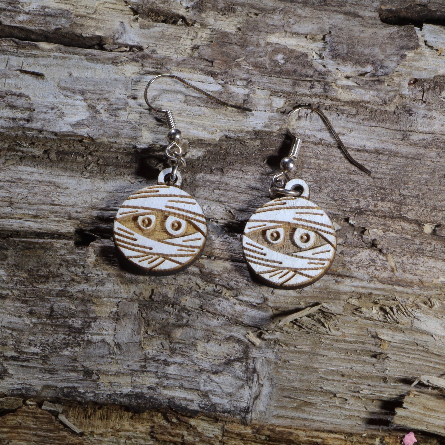 Hand-painted wooden mummy dangle earrings featuring a wrapped Halloween mummy with spooky details. Lightweight Halloween earrings with hypoallergenic .925 sterling silver hooks, perfect for spooky season, trick-or-treat events, Halloween parties, haunted attractions, and anyone who loves creepy-cute Halloween jewelry.