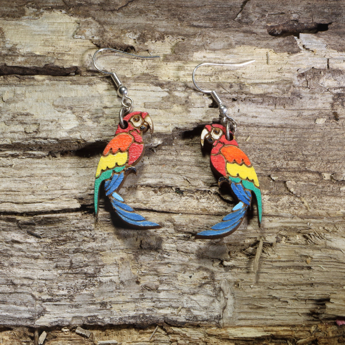 Hand-painted wooden parrot dangle earrings featuring colorful tropical parrots with red, orange, yellow, green, and blue feathers on hypoallergenic .925 sterling silver hooks. Lightweight bird jewelry perfect for parrot lovers, tropical wildlife enthusiasts, and colorful nature-inspired style.