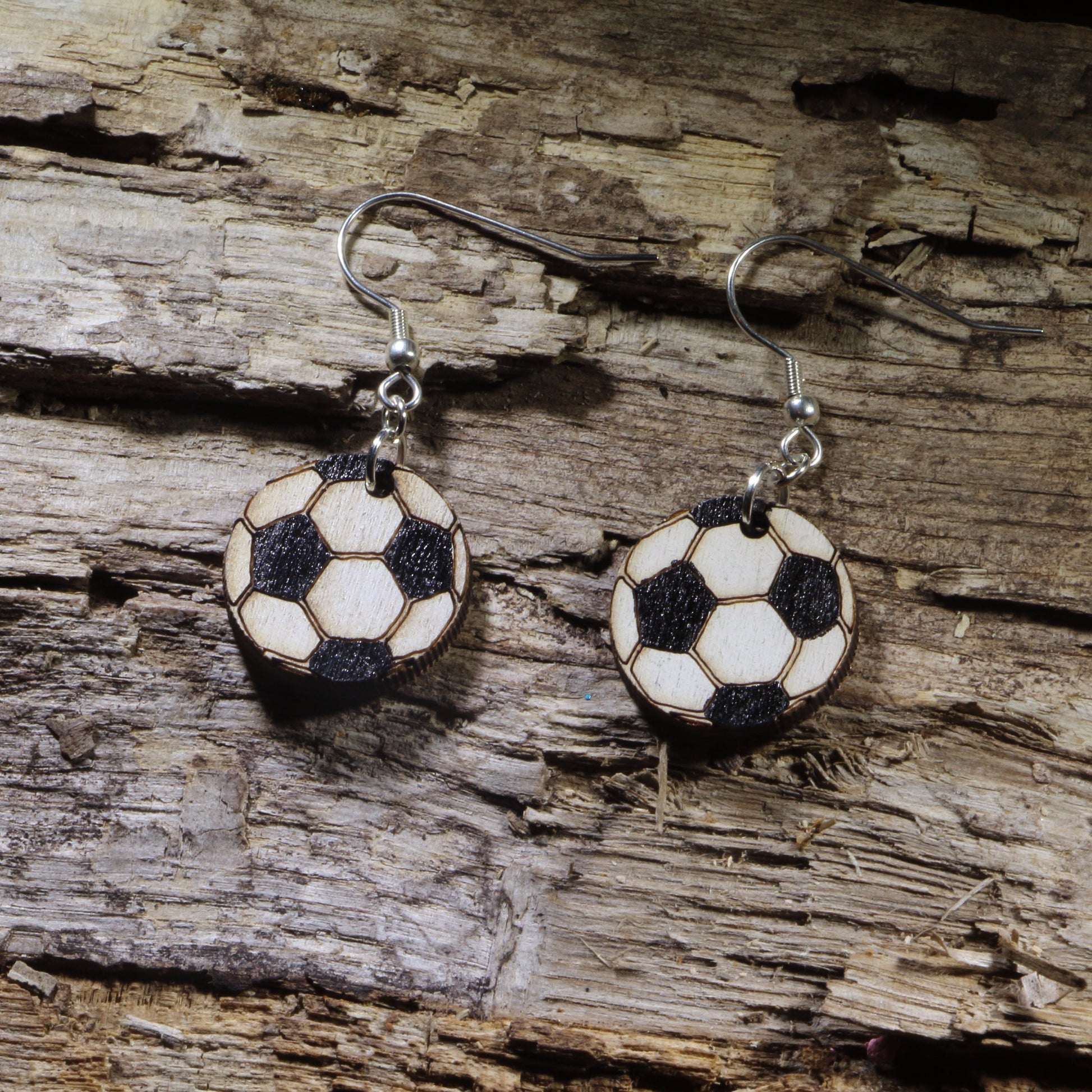 Hand-painted wooden soccer ball dangle earrings featuring the classic black-and-white soccer ball design. Lightweight sports earrings with hypoallergenic .925 sterling silver hooks, perfect for soccer players, coaches, referees, team moms, sports fans, and anyone who loves the world's favorite game.