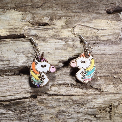 Hand-painted wooden unicorn head dangle earrings featuring a white unicorn with a rainbow mane and gold horn on hypoallergenic .925 sterling silver hooks. Lightweight fantasy-inspired jewelry for unicorn lovers, magical creature fans, colorful accessory collectors, and whimsical gift giving.