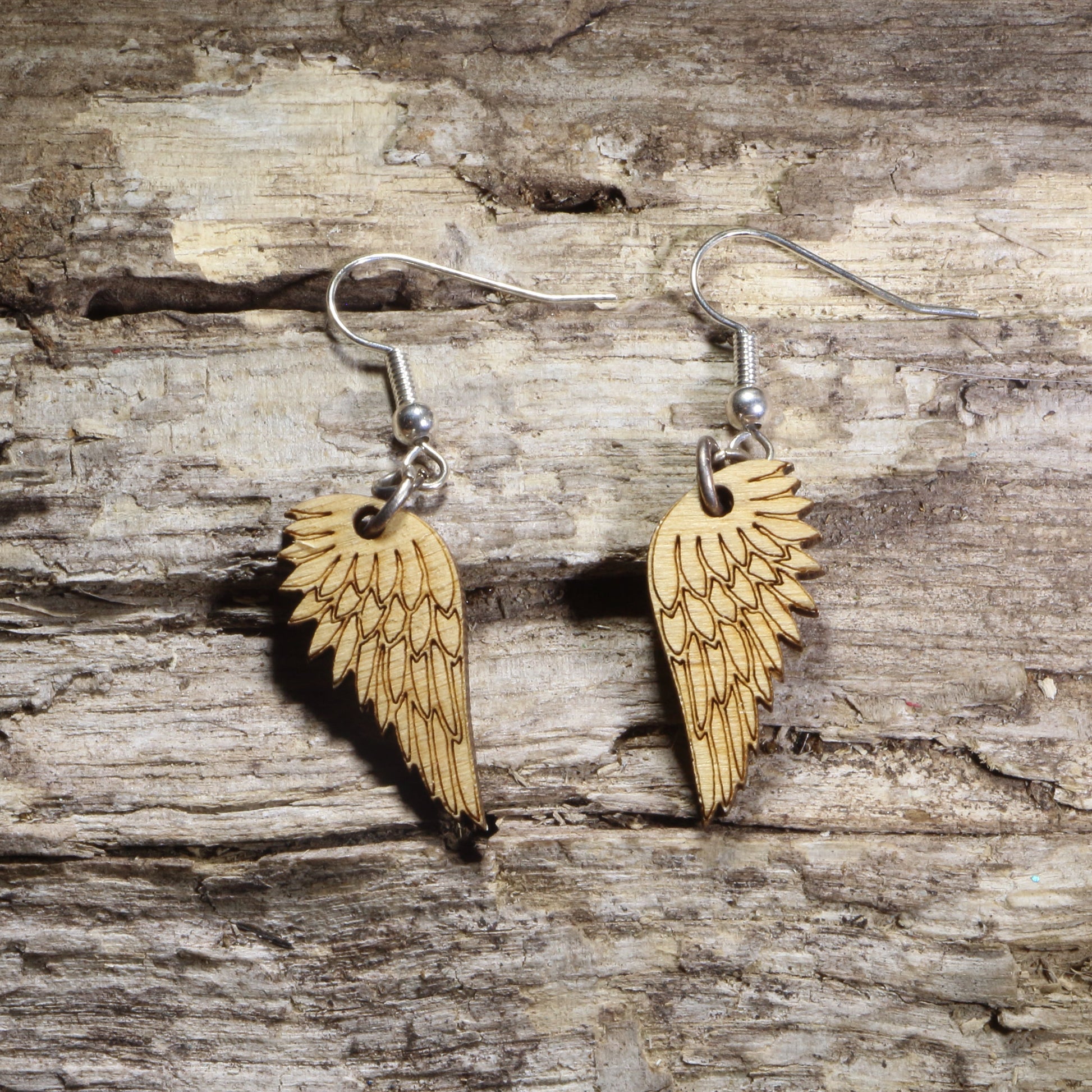 Handcrafted Angel Wing wooden dangle earrings featuring intricately engraved feathered wings. Lightweight laser-cut wooden earrings with hypoallergenic .925 sterling silver hooks, perfect for angel lovers, memorial gifts, spiritual jewelry, faith-inspired accessories, celestial fashion, and everyday wear.