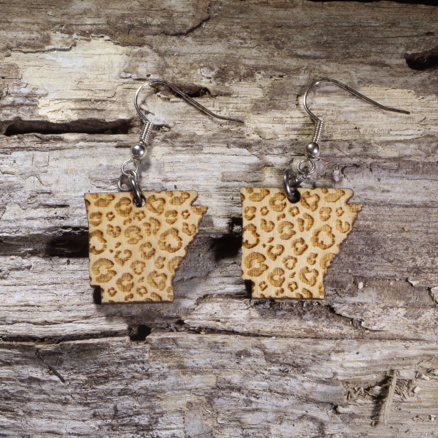 Handcrafted Arkansas Leopard Print wooden dangle earrings featuring the outline of Arkansas with a stylish leopard print pattern. Lightweight laser-cut wooden earrings with hypoallergenic .925 sterling silver hooks, perfect for Arkansas pride, Southern fashion, animal print lovers, state jewelry collectors, and unique everyday accessories.