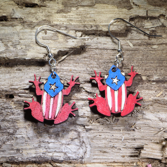 Handcrafted Coquí frog wooden dangle earrings featuring the iconic Puerto Rican tree frog decorated with the Puerto Rico flag. Lightweight hand-painted wooden earrings with hypoallergenic .925 sterling silver hooks, perfect for Puerto Rican pride, island heritage, Boricua gifts, Caribbean culture, travel souvenirs, and patriotic accessories.