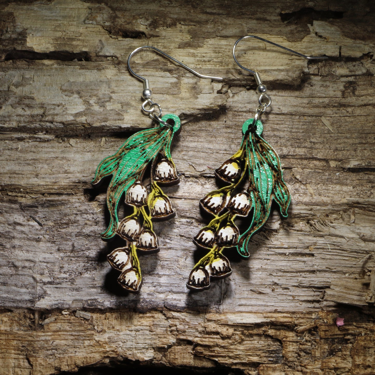 Handcrafted Lily of the Valley wooden dangle earrings featuring delicate white bell-shaped flowers with hand-painted green leaves. Lightweight laser-cut wooden earrings with hypoallergenic .925 sterling silver hooks, perfect for flower lovers, gardeners, spring fashion, botanical jewelry, birth flower gifts, and handmade floral earrings.