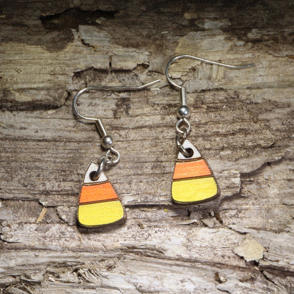 Handcrafted candy corn wooden dangle earrings featuring the classic white, orange, and yellow Halloween candy design. Lightweight hand-painted wooden earrings with hypoallergenic .925 sterling silver hooks, perfect for Halloween parties, trick-or-treat season, spooky fall outfits, candy lovers, and festive autumn accessories.