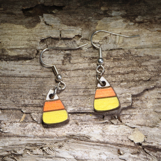 Handcrafted candy corn wooden dangle earrings featuring the classic white, orange, and yellow Halloween candy design. Lightweight hand-painted wooden earrings with hypoallergenic .925 sterling silver hooks, perfect for Halloween parties, trick-or-treat season, spooky fall outfits, candy lovers, and festive autumn accessories.