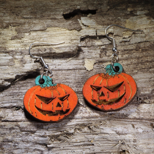 Handcrafted jack-o'-lantern wooden dangle earrings featuring classic carved Halloween pumpkins with hand-painted orange and green details. Lightweight laser-cut wooden earrings with hypoallergenic .925 sterling silver hooks, perfect for Halloween parties, spooky season outfits, pumpkin lovers, fall festivals, and handmade Halloween jewelry.
