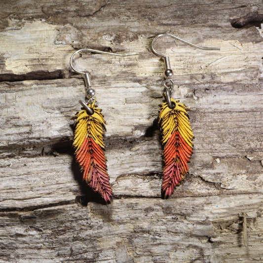 Handcrafted ombré feather wooden dangle earrings featuring hand-painted yellow, orange, and red gradient feathers with engraved detailing. Lightweight laser-cut wooden earrings with hypoallergenic .925 sterling silver hooks, perfect for boho fashion, autumn accessories, nature lovers, festival wear, and colorful handcrafted jewelry.