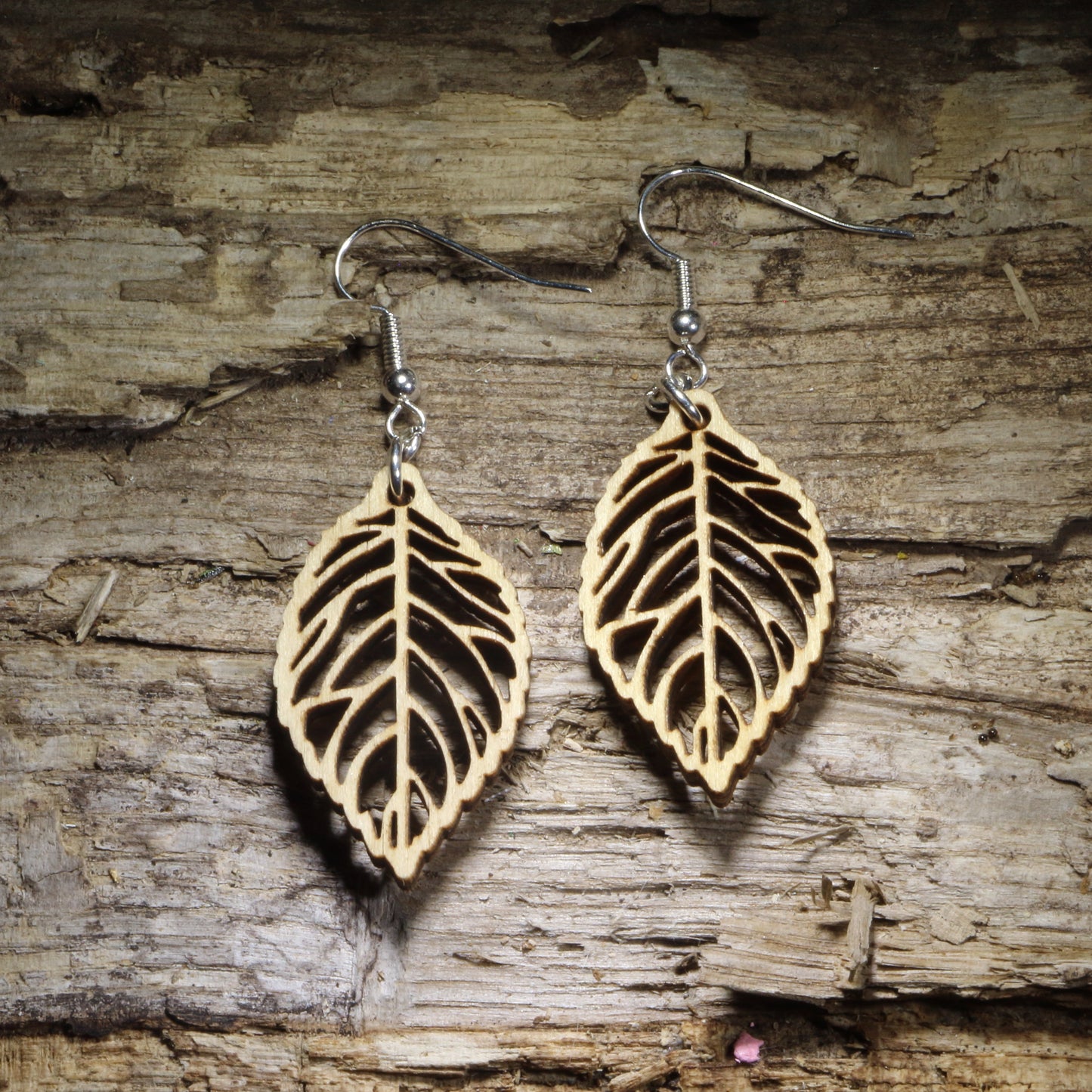 Handcrafted skeleton leaf wooden dangle earrings featuring an intricate laser-cut leaf vein design in natural Baltic birch wood. Lightweight wooden earrings with hypoallergenic .925 sterling silver hooks, perfect for nature lovers, botanical jewelry fans, woodland style, fall fashion, eco-friendly accessories, and handmade leaf earrings.