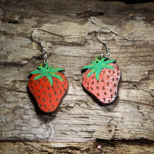 Handcrafted strawberry wooden dangle earrings featuring bright hand-painted red strawberries with green leaves and detailed seed accents. Lightweight laser-cut wooden earrings with hypoallergenic .925 sterling silver hooks, perfect for strawberry lovers, cottagecore fashion, fruit jewelry fans, gardeners, summer accessories, farmers market style, and handmade botanical jewelry.