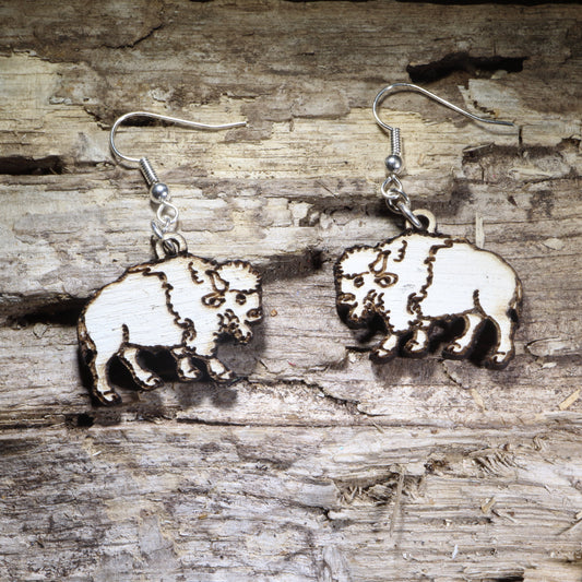 Handcrafted white buffalo wooden dangle earrings featuring a detailed American bison silhouette with engraved accents. Lightweight laser-cut wooden earrings with hypoallergenic .925 sterling silver hooks, perfect for wildlife lovers, Western style, National Park enthusiasts, buffalo fans, and handmade nature-inspired jewelry.