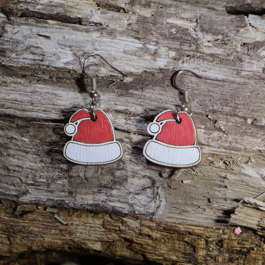 Handcrafted wooden Santa hat dangle earrings featuring the iconic red and white Christmas hat. These lightweight holiday earrings are hand-painted and finished with hypoallergenic .925 sterling silver hooks, making them perfect for Christmas parties, holiday events, festive outfits, Secret Santa gifts, stocking stuffers, and celebrating the holiday season in cheerful style.